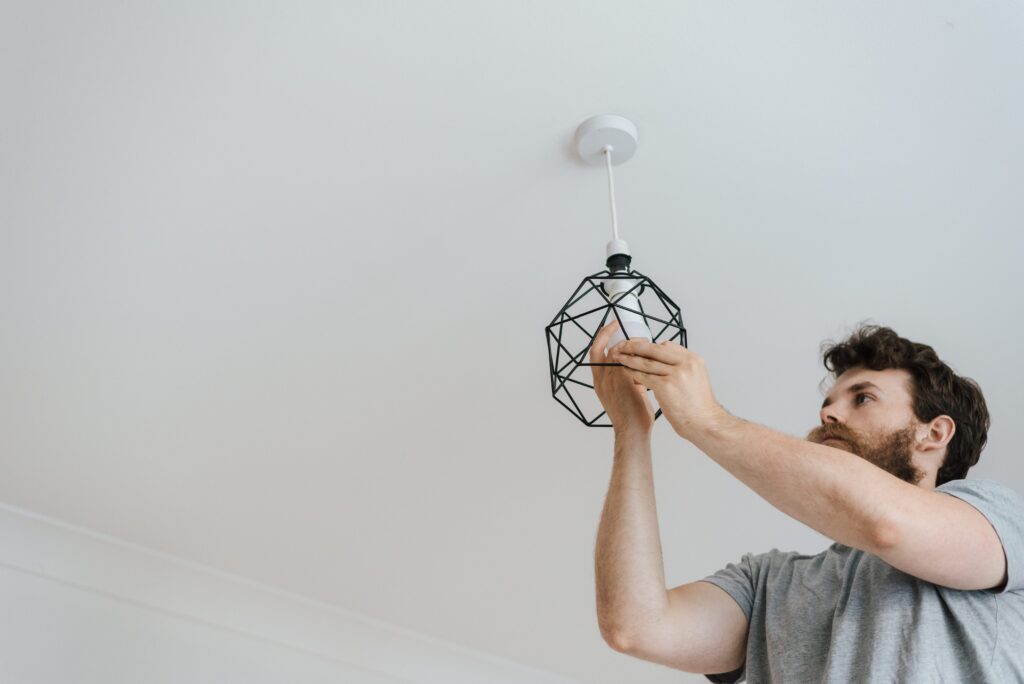  Man screwing a light bulb into the lamp